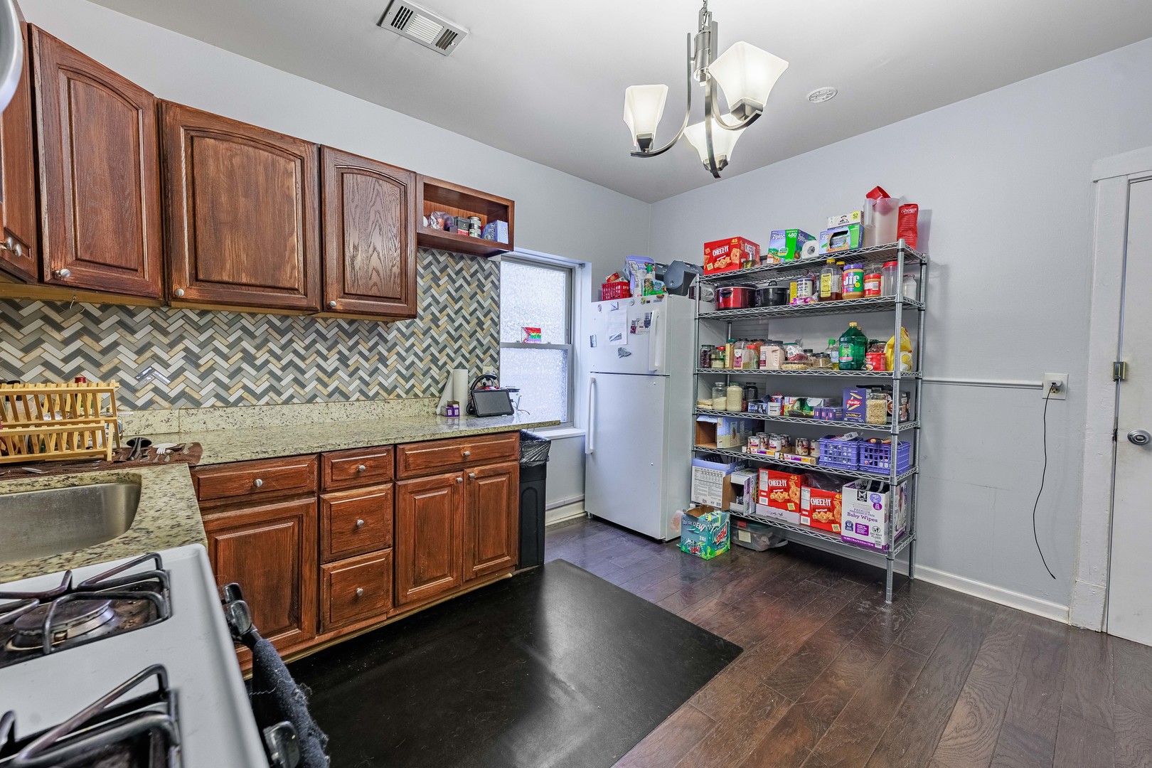 5935 West Patterson Avenue Chicago, IL 60634 - Photo 30 of 34 a kitchen with stainless steel appliances granite countertop a refrigerator a stove a sink dishwasher and a dining table with wooden floor