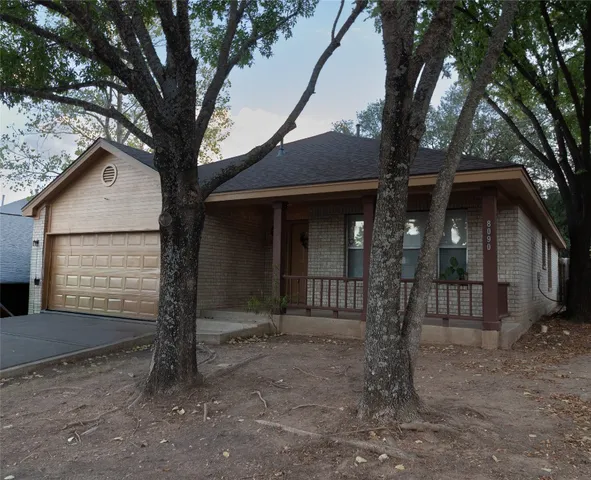 a view of a house with a tree in the yard