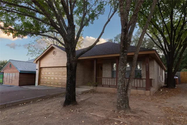a view of a house with a tree and wooden fence