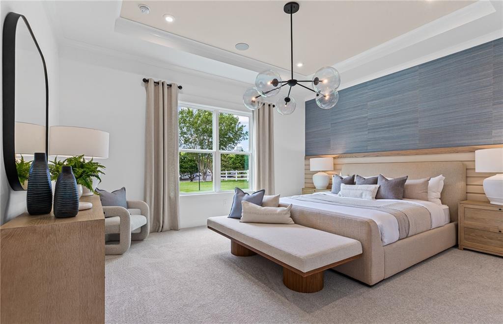 299 Rockledge Bend Powder Springs, GA 30127 - Photo 9 of 12 a spacious bedroom with a bed a chandelier and a couch