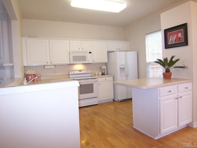 7230 Galon Glen Road Raleigh, NC 27613 - Photo 5 of 12 a kitchen with white cabinets and white appliances