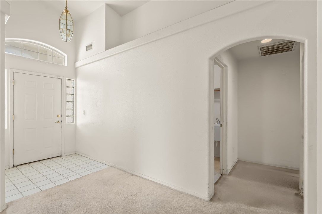 2853 Winchester Road Bullhead City, AZ 86442 - Photo 10 of 40 Entryway featuring a white door, an arched transom window, a decorative hanging light fixture, and white floor tiles