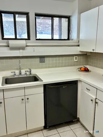 a kitchen with white cabinets and a sink