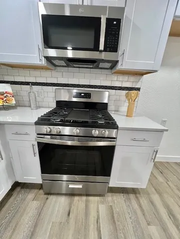 a stove top oven sitting inside of a kitchen
