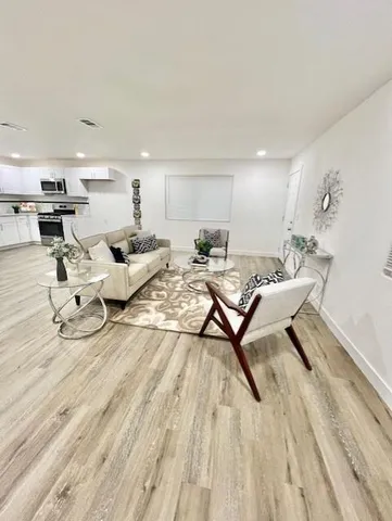 a living room with furniture and a wooden floor