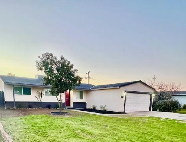 a view of a house with a yard and sitting area