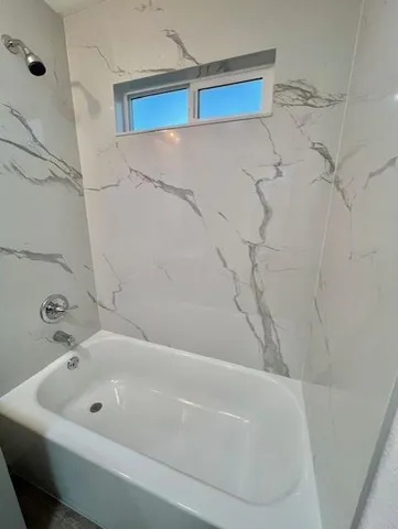 a bathroom with a bathtub and shower