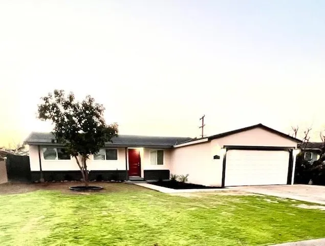 a view of a house with a yard and sitting area