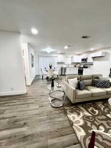 a living room with furniture and wooden floor