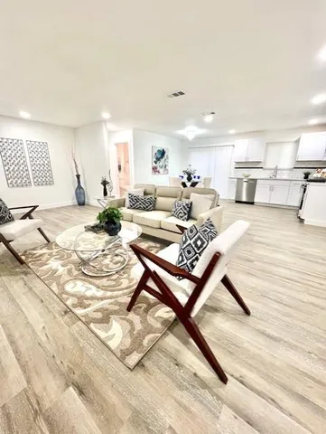 a living room with furniture and a wooden floor