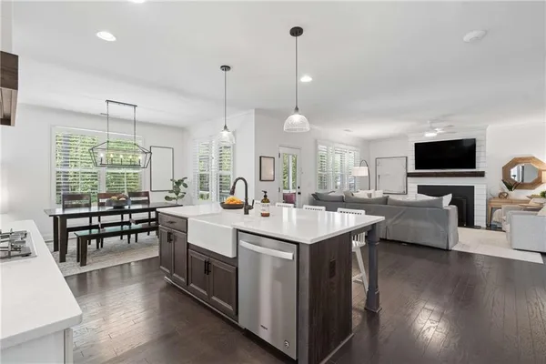 a large white kitchen with a stove and sitting area