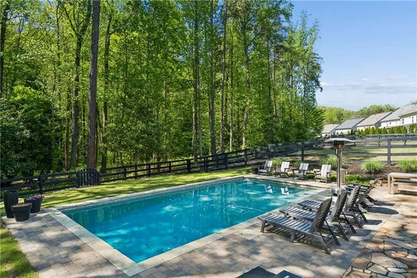 a view of a house with pool and chairs