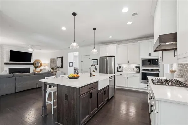 a kitchen with a sink a counter top space stainless steel appliances and cabinets