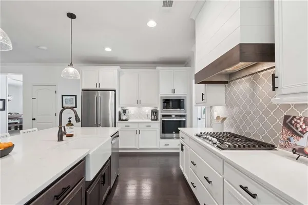 a kitchen with stainless steel appliances kitchen island a sink stove and refrigerator