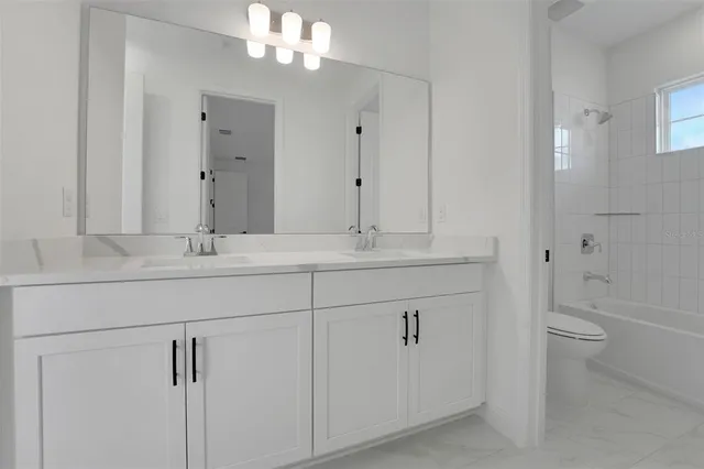 a bathroom with a sink a toilet and bathtub