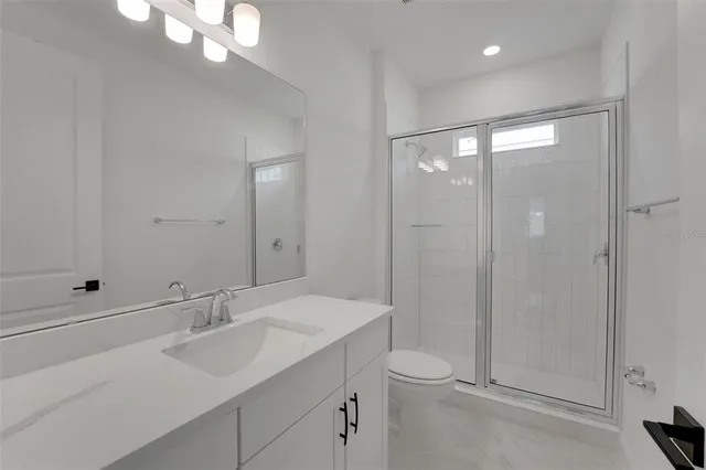 a view of a kitchen with white cabinets and wooden floor