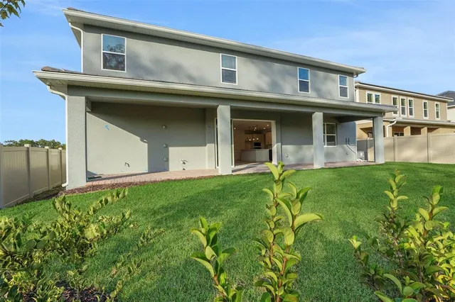 a view of a house with brick walls and a yard with plants