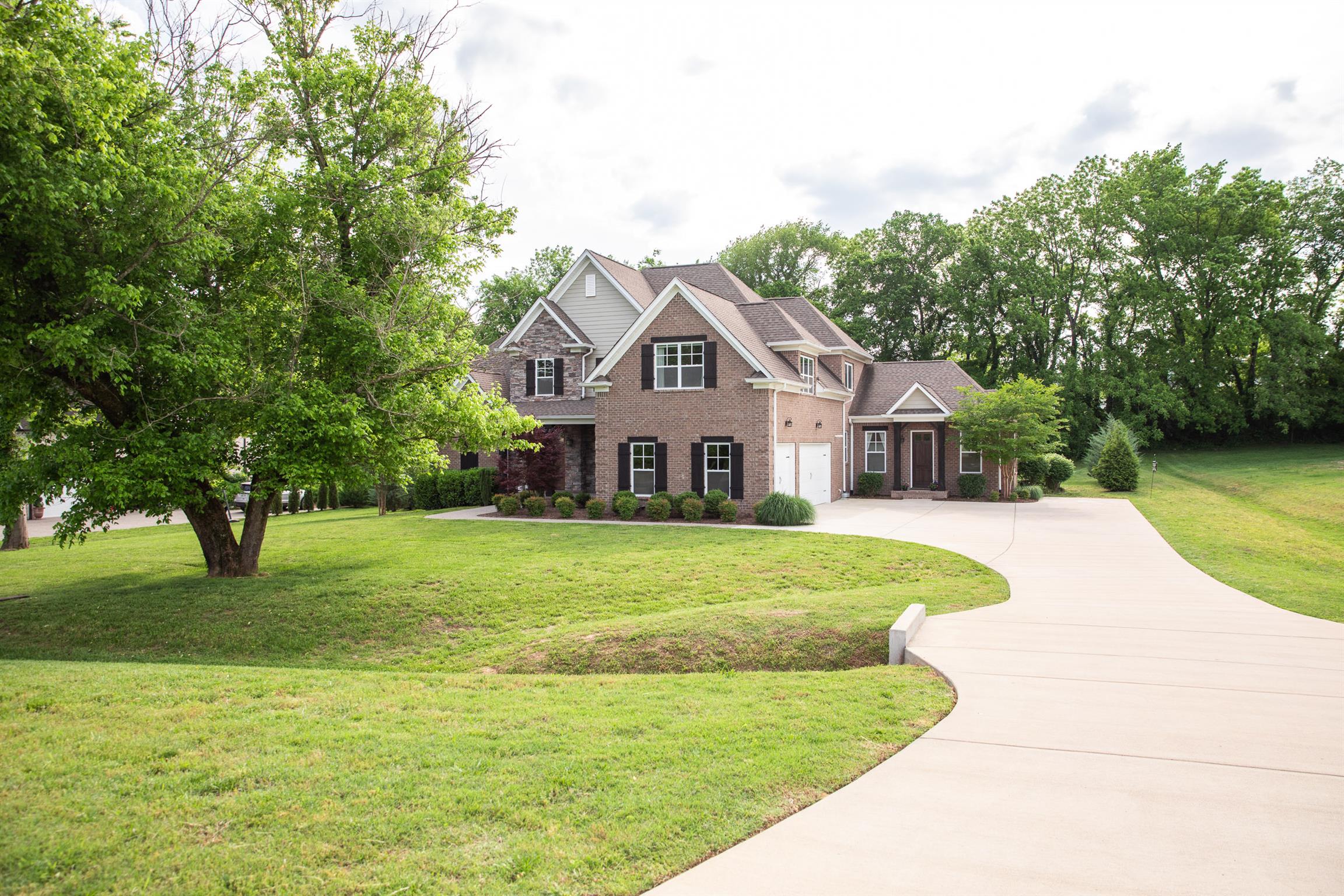 4309 Gallant Ridge Drive Franklin, TN 37064 - Photo 28 of 30 Extra wide driveway for guest parking and ample turnaround space. Lush landscaping and mature trees were maintained. Brick, stone, and Hardie construction. Home and property have been meticulously maintained.