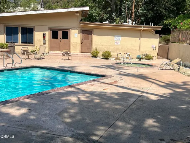 a view of a patio with a table and chairs under an umbrella