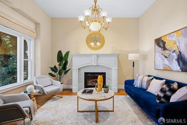 a living room with furniture a fireplace and a large mirror