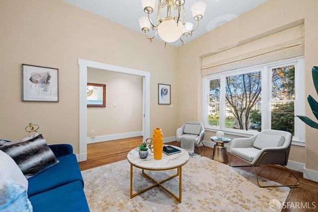 a living room with furniture chandelier and a large window