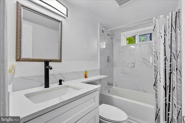 a bathroom with a sink a toilet and bathtub