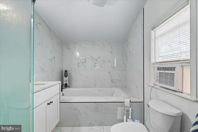 a bathroom with a granite countertop sink toilet a mirror and shower