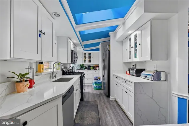 a kitchen with white cabinets a sink stove and refrigerator