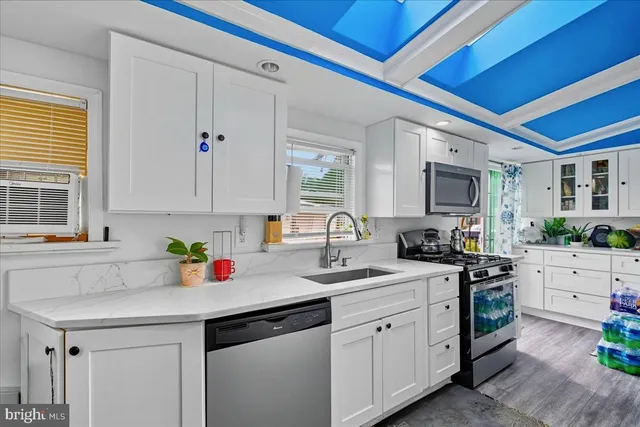 a kitchen with white cabinets and appliances