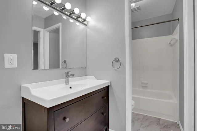 a bathroom with a sink mirror and a bathtub