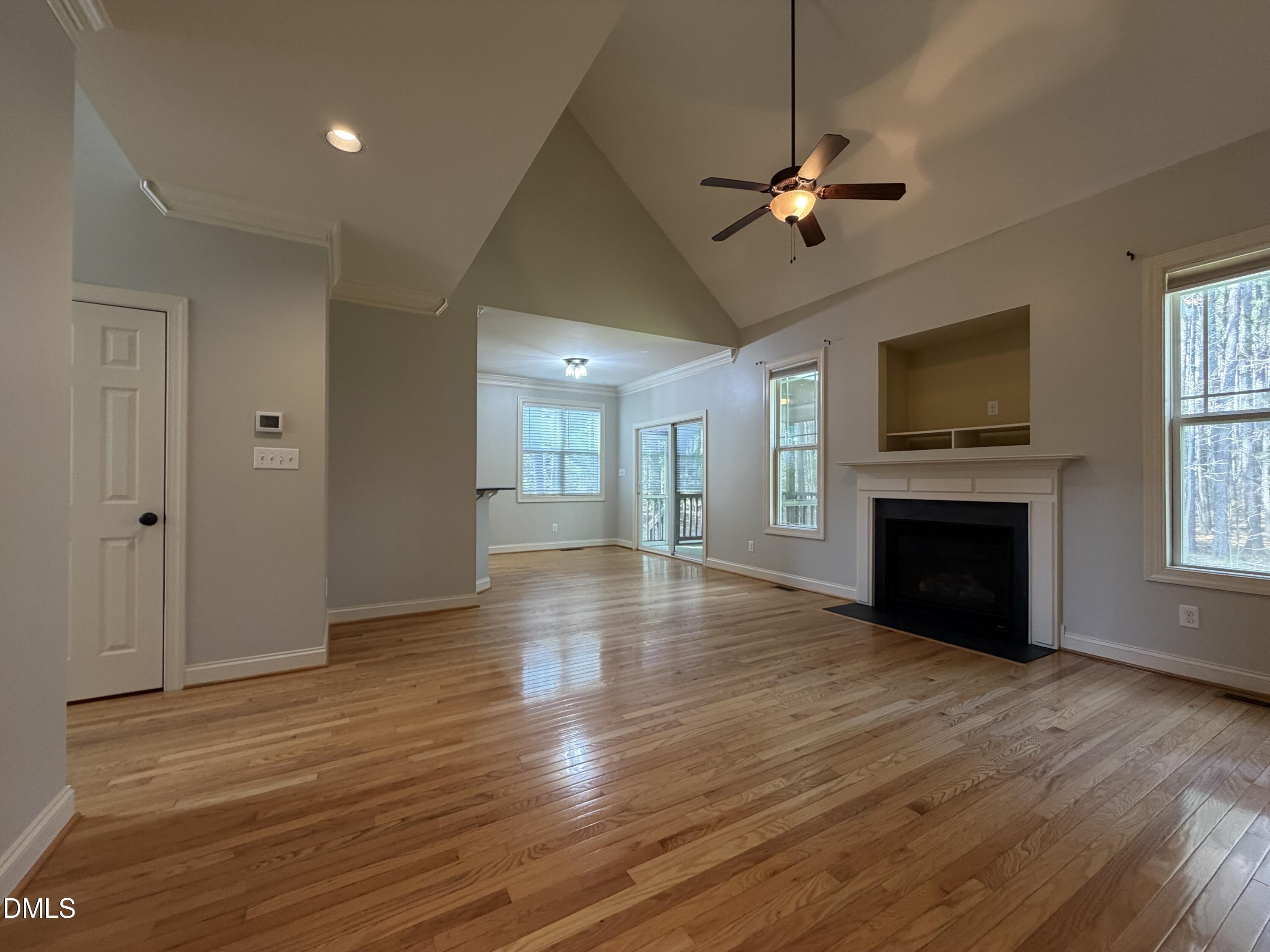 204 Blair Hills Road Wendell, NC 27591 - Photo 13 of 52 a view of a livingroom with a fireplace wooden floor and a ceiling fan