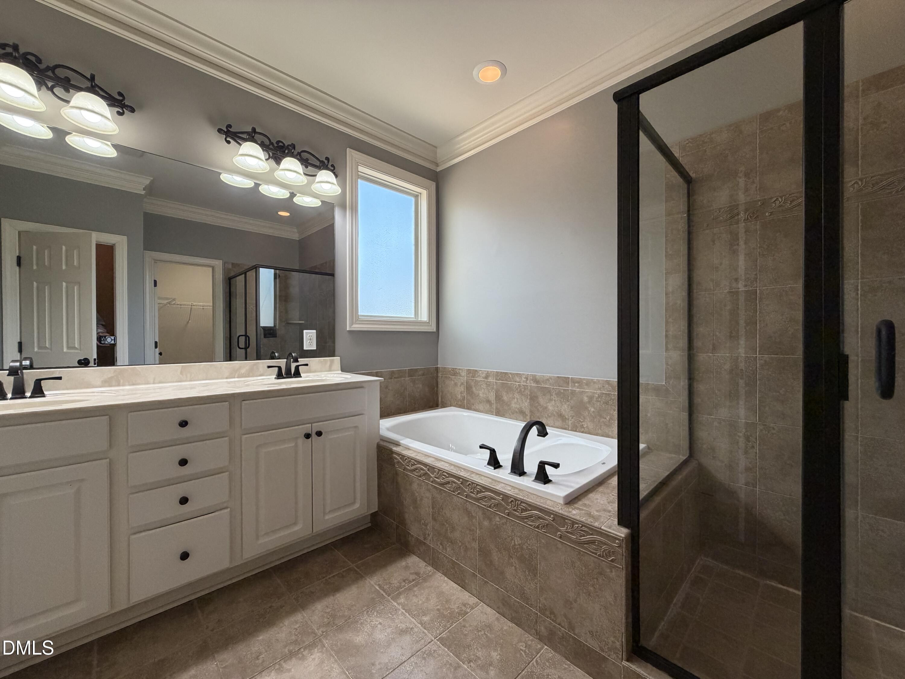 204 Blair Hills Road Wendell, NC 27591 - Photo 27 of 52 a bathroom with a tub a double vanity sink and a mirror