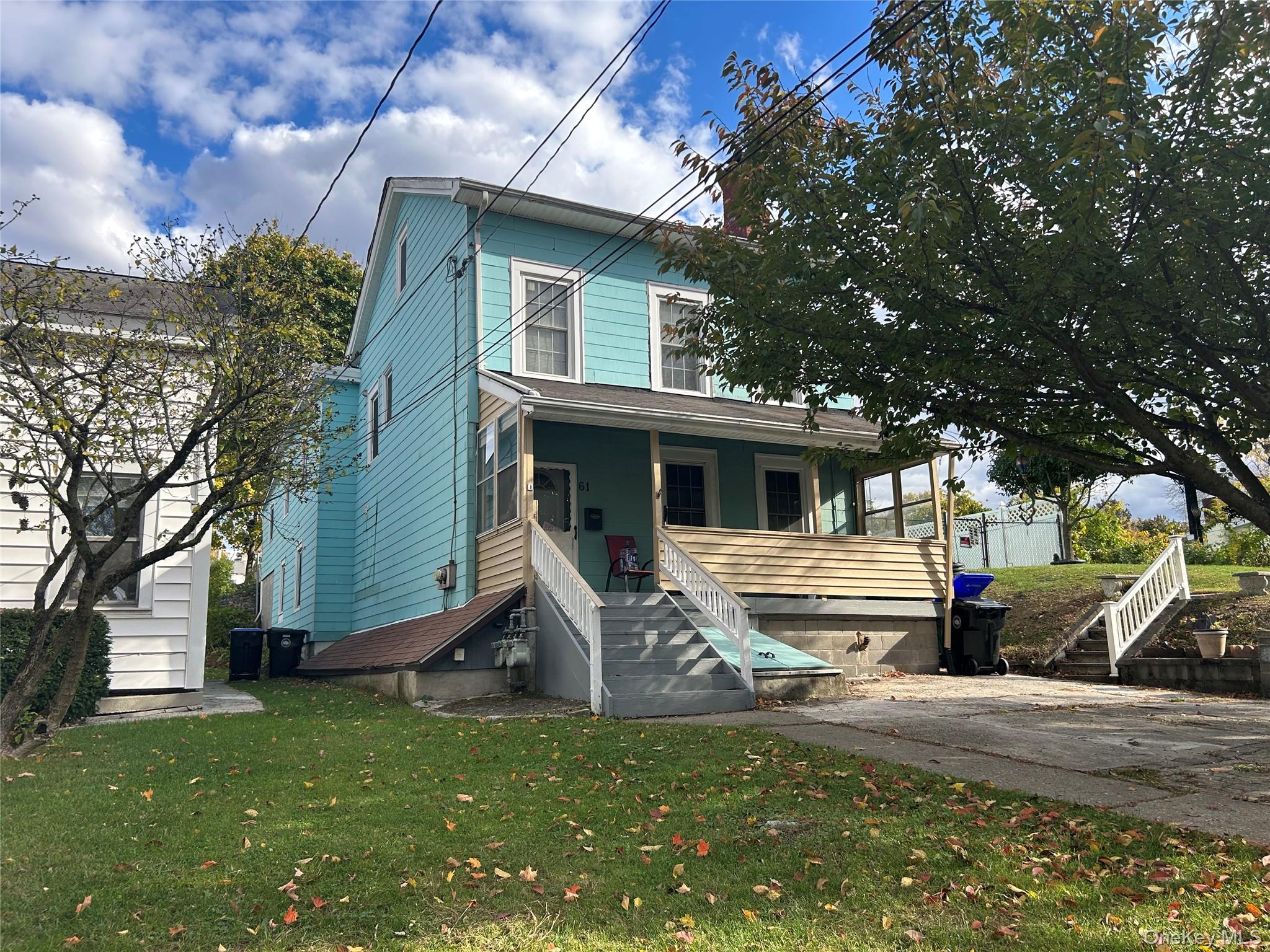 a front view of a house with a tree