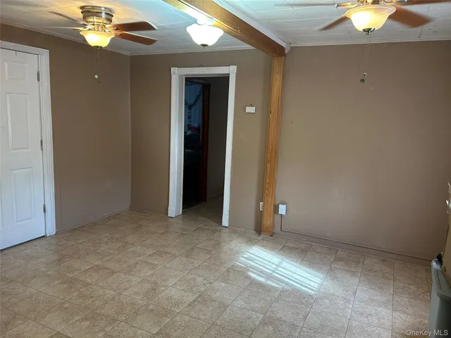 an empty room with a chandelier fan and closet