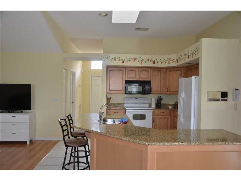 155 Midvale Terrace Sebastian, FL 32958 - Photo 10 of 16 a kitchen with stainless steel appliances kitchen island granite countertop a refrigerator and a stove top oven
