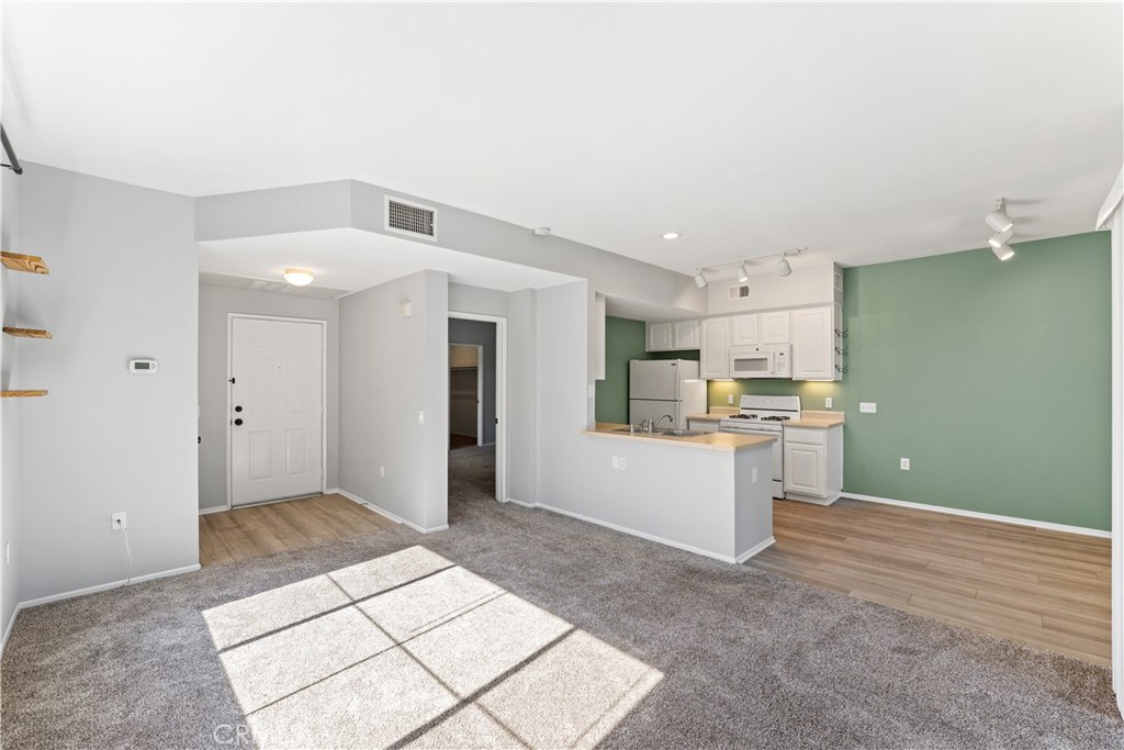 20000 Plum Canyon Road, Unit 1221 Saugus, CA 91350 - Photo 5 of 20 a view of a kitchen with refrigerator and white cabinets