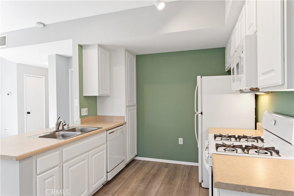 20000 Plum Canyon Road, Unit 1221 Saugus, CA 91350 - Photo 9 of 20 a kitchen with cabinets and white appliances