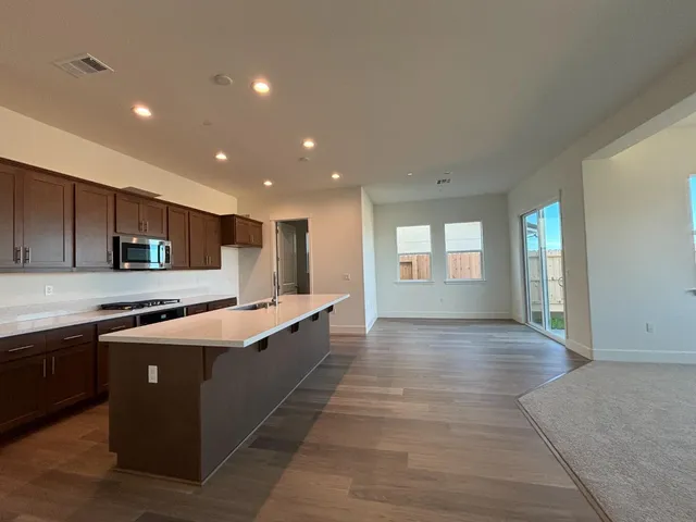 a large kitchen with stainless steel appliances granite countertop a large counter top and oven