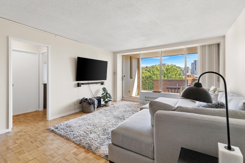 33 Pond Avenue, Unit 709 Brookline, MA 02445 - Photo 3 of 29 a living room with furniture and a flat screen tv