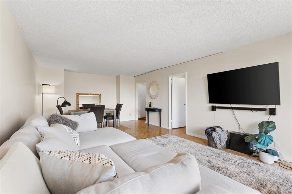 33 Pond Avenue, Unit 709 Brookline, MA 02445 - Photo 6 of 29 a living room with furniture and a flat screen tv
