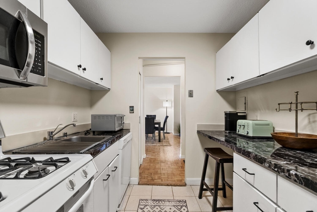 33 Pond Avenue, Unit 709 Brookline, MA 02445 - Photo 9 of 29 a kitchen with stainless steel appliances a sink a stove and cabinets