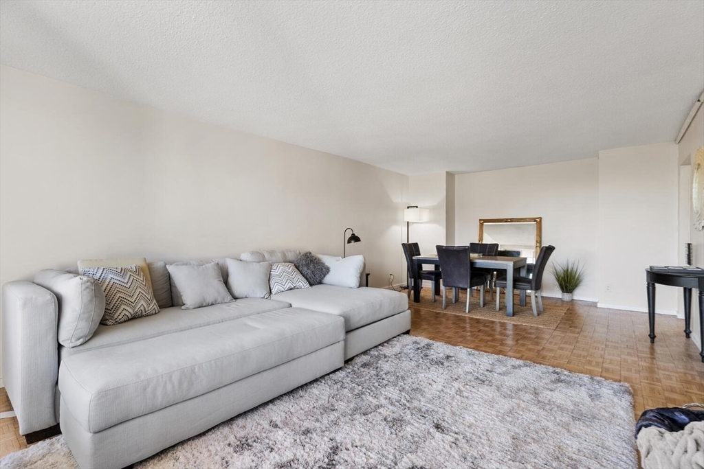 33 Pond Avenue, Unit 709 Brookline, MA 02445 - Photo 10 of 29 a living room with furniture and a dining table with kitchen view