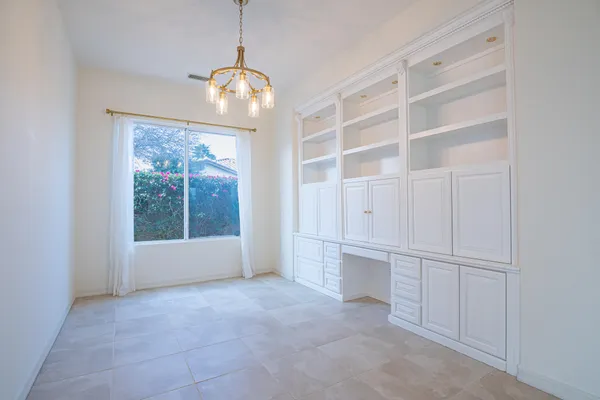 a kitchen with a table chairs refrigerator and cabinets