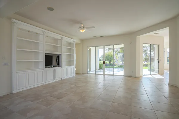 a view of an empty room with window and cabinet