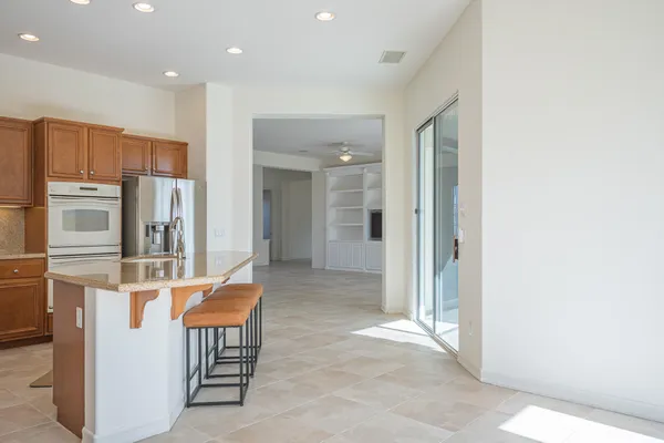 a living room with stainless steel appliances furniture refrigerator and cabinets