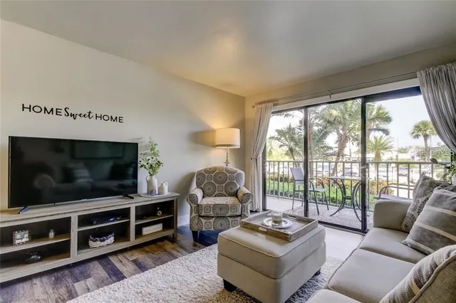 a living room with furniture a flat screen tv and a floor to ceiling window