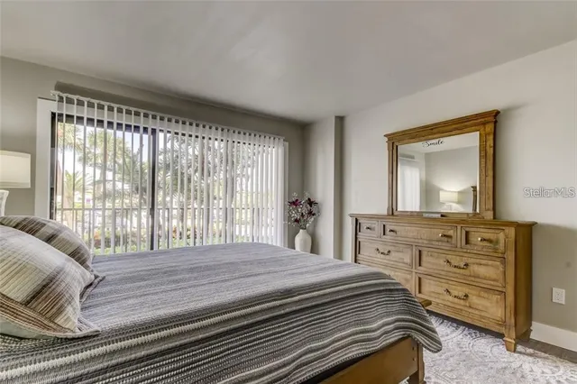 a bedroom with a bed and a mirror on dresser