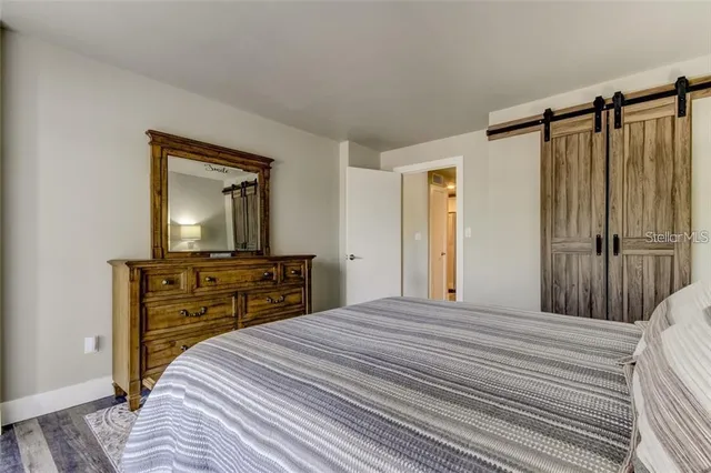 a bedroom with a bed and a flat tv screen on dresser