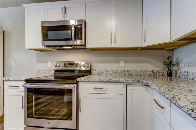 a kitchen with stainless steel appliances granite countertop a sink and a microwave
