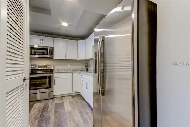 a kitchen with a refrigerator and a stove top oven